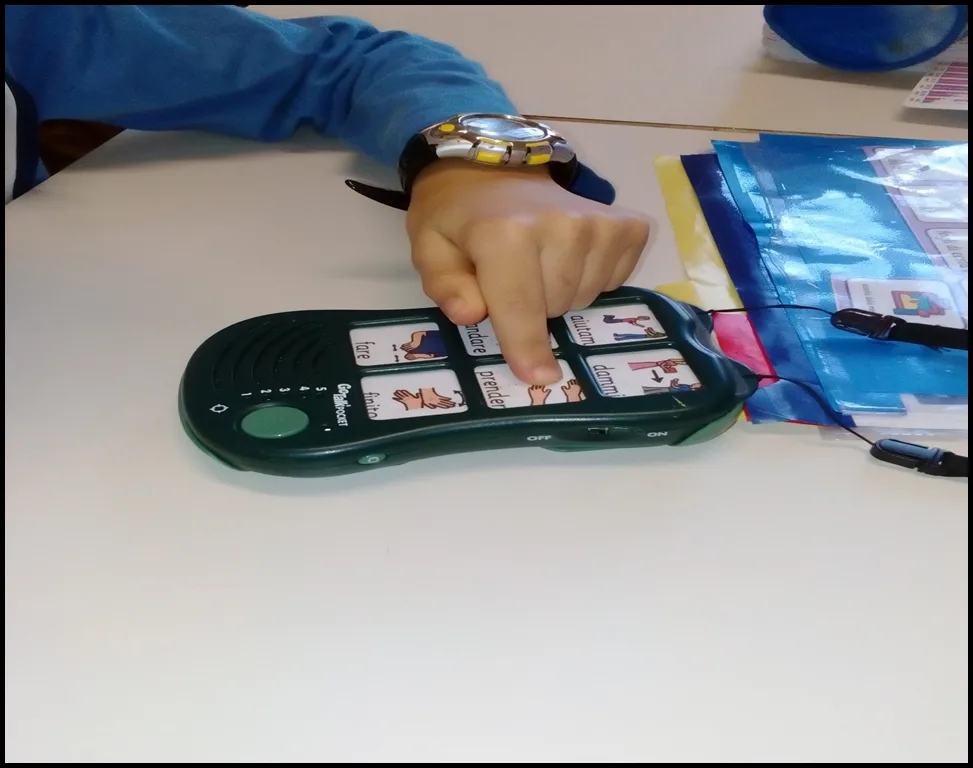 Bambino che utilizza un comunicatore con simboli di Comunicazione Aumentativa Alternativa