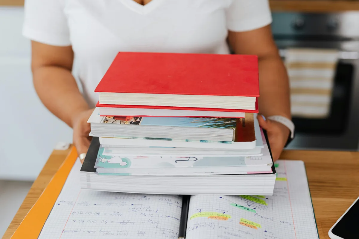 Studentessa universitaria con una pila di libri